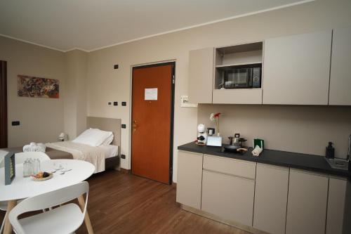 eine Küche und ein Schlafzimmer mit einem Bett und einem Tisch in der Unterkunft Bnbook Expo Residence Rho in Rho