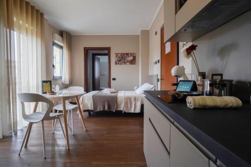 a kitchen with a table and a room with a bed at Bnbook Expo Residence Rho in Rho