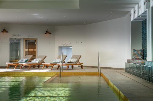 a pool of water in a room with benches at Harbour Beach Club, Hotel & Spa in Salcombe