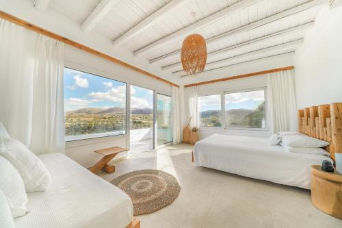 a bedroom with two beds and a large window at Villa Kalimera swimming pool Pitsidia Matala Komos in Pitsidia