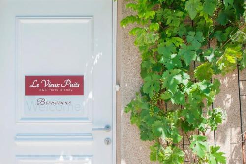 une porte avec un panneau sur le côté du bâtiment dans l'établissement Le Vieux Puits Paris Est Paris-Disney, à Noisy-le-Grand