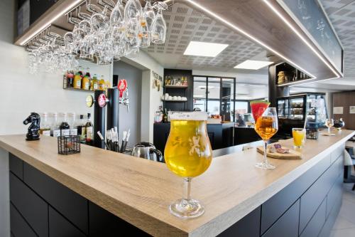 a bar with two glasses of beer on a counter at All Suites Appart Hôtel - Dunkerque Centre in Dunkerque