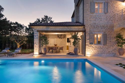 einen Pool vor einem Haus mit einer Terrasse in der Unterkunft Villa Elena u Ladicima for 8 people with private pool & sports complex in Central Istria in Ladići