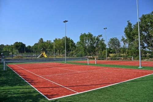 einen Tennisplatz mit einem roten Tennisplatz in der Unterkunft Villa Elena u Ladicima for 8 people with private pool & sports complex in Central Istria in Ladići