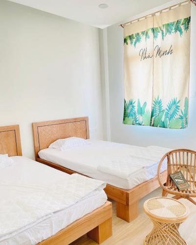 two beds in a room with a table and chairs at Vui Homestay in Xóm Trương Quít