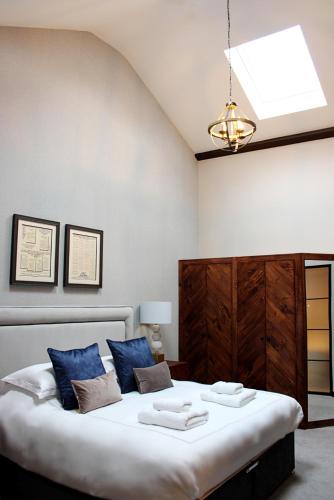 a bedroom with a large bed with blue pillows at The Merchant's Yard in Tideswell