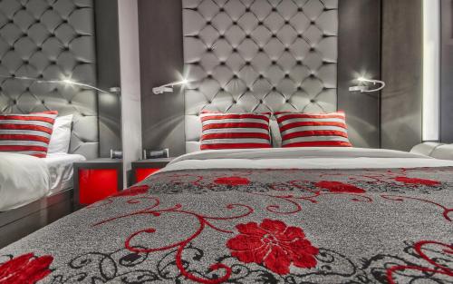 a bedroom with a bed with red and white pillows at Hôtel Plaza Québec par JARO in Quebec City