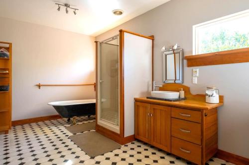 梅斯文的住宿－Forest House Methven，浴室配有盥洗盆和浴缸。