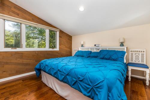 1 dormitorio con 1 cama con edredón azul en Fox Wood Path Getaway en Galena