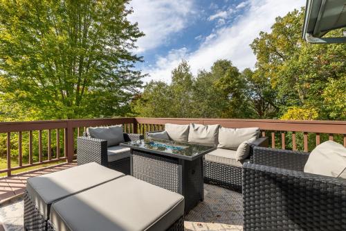 a patio with wicker chairs and tables on a deck at Fox Wood Path Getaway in Galena