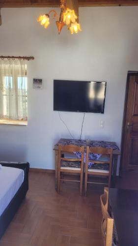 a living room with a tv and a table with a bed at KASTRI in Kýthira