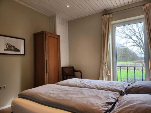um quarto com 2 camas e uma janela em Landhuis de heibloem em Heythuysen