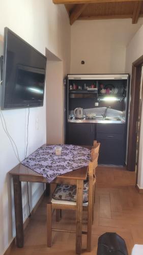 a kitchen with a table and a tv in a room at KASTRI in Kýthira