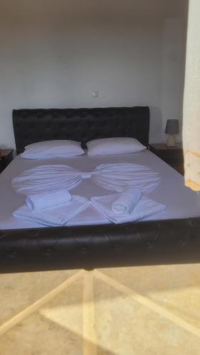 Una cama con sábanas blancas y almohadas blancas. en KASTRI, en Citera