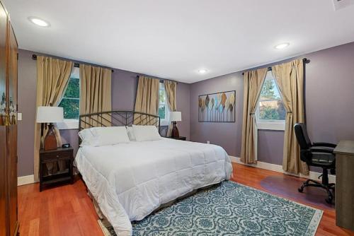 1 dormitorio con 1 cama, escritorio y ventanas en Downtown Spearfish Historic Home, en Spearfish