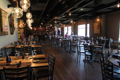 a restaurant with wooden tables and chairs in a room at Warehouse Hotel at The Nook in Manheim
