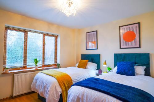 duas camas num quarto com duas janelas em Eagle homely apartment em Kettering