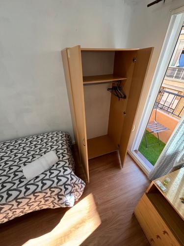 Habitación pequeña con cama y armario en Cute and Cosy habitación privada con balcón en Valencia