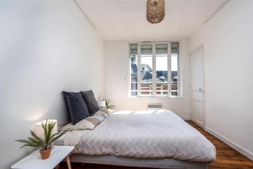 une chambre blanche avec un lit et une fenêtre dans l'établissement Le Jacobin / 1 Chambre - Netflix - Hyper centre, à Amiens