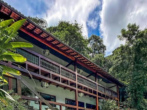 a building with a roof with trees in the background at Casa Verde Río in Rio de Janeiro