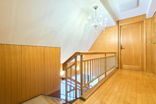 a hallway with a staircase and a chandelier at L-Large 3Bedroom Luxury Condo, 140sqm Max 19 PPL, 7mins walk to station, Elevator,QuiteArea in Tokyo