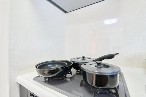 two pots on top of a stove in a kitchen at L-Large 3Bedroom Luxury Condo, 140sqm Max 19 PPL, 7mins walk to station, Elevator,QuiteArea in Tokyo