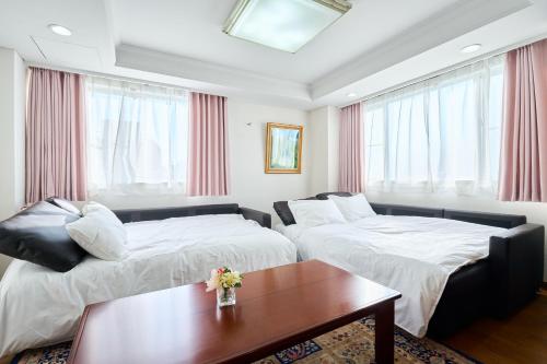 a hotel room with two beds and a table at L-Large 3Bedroom Luxury Condo, 140sqm Max 19 PPL, 7mins walk to station, Elevator,QuiteArea in Tokyo