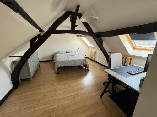 a bedroom with a bed and a desk with a laptop at Jolie maison avec Salon Cinéma in Mouy
