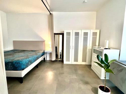 sypialnia z łóżkiem, szafką i rośliną w obiekcie Valley of Business Dortmund - Apartment w Garden - Phoenix-See w Dortmundzie
