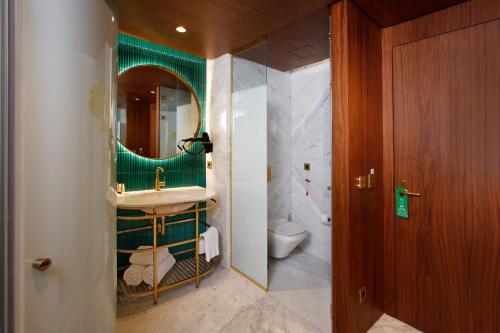 a bathroom with a sink and a mirror and a toilet at Kate Hotel Special Class & SPA in Istanbul