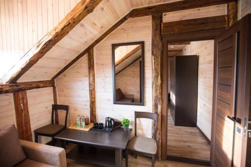 a dining room in a log cabin with a table and chairs at Готель Бережани in Brzezhany