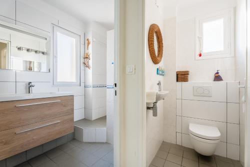 une salle de bain blanche avec des toilettes et un lavabo dans l'établissement Le Marignan par Dodo à Cassis, à Cassis
