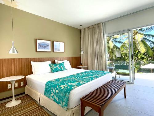 a bedroom with a large bed and a large window at Casa de Praia em Interlagos - 4 suítes a poucos metros do mar in Camaçari