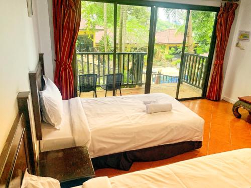 a bedroom with a large bed and a balcony at patong beautiful pool villa in Patong Beach