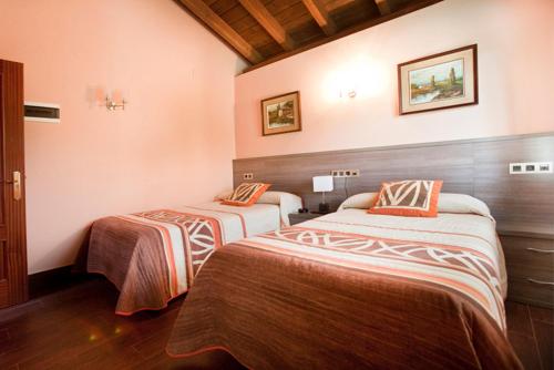 A bed or beds in a room at Hotel Rural Las Palmeras Muskiz