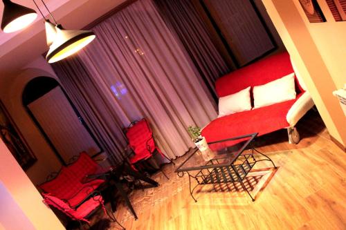a living room with a red couch and two chairs at Royal Venezia Hotel in Batumi