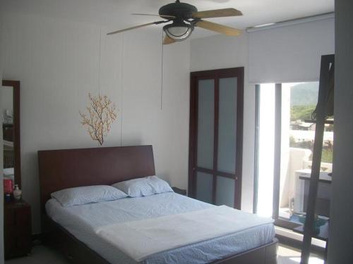 um quarto com uma cama e uma ventoinha de tecto em Balcones de Costa Azul Apto 302 em Santa Marta