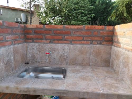 ein Edelstahlspülbecken in einer Ziegelwand in der Unterkunft Chicharrita in Sierra de la Ventana