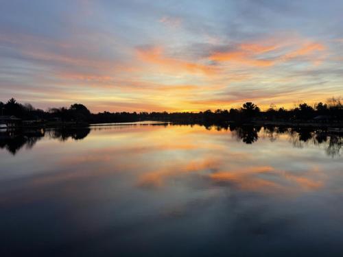 a large body of water with a sunset in the background at Bridge Inn Tomahawk - Room 107, 2 Queen Beds, Pet Friendly, Laminate Wood Flooring , Walkout, River View in Tomahawk