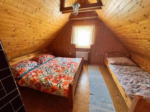Chatka Hanka في تيرشوفا: غرفة نوم بسريرين في كابينة خشبية
