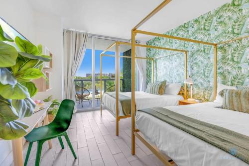 a bedroom with two beds and a green chair at Tropical Apartment - Balcony - Resort, Pool - Gym in Hallandale Beach