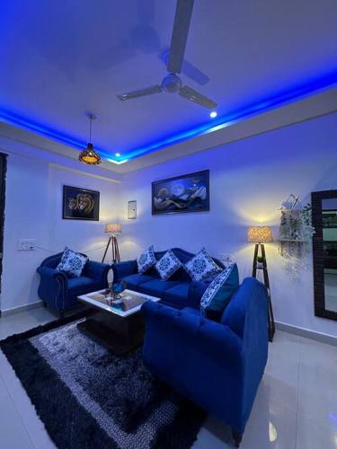 een woonkamer met een blauw plafond en een blauwe bank bij Your cozy home in Dehradun