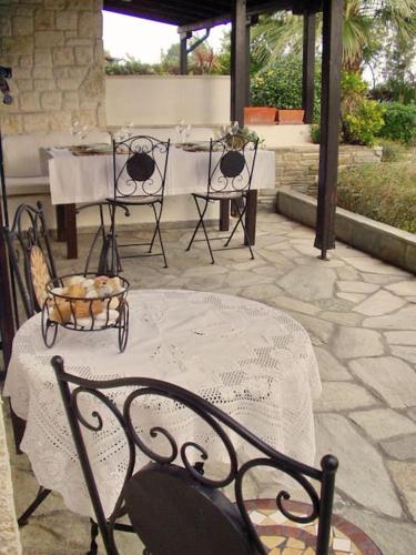 a patio with a table and two chairs and a table and a table and chairs at Cozy and Stylish Pool House in Kriopigi