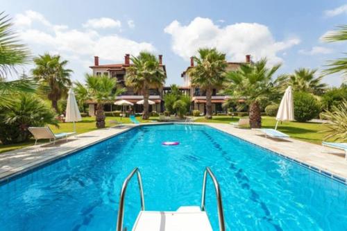 a swimming pool in front of a villa at Cozy and Stylish Pool House in Kriopigi