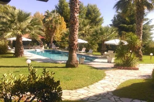 a resort with a swimming pool with palm trees at Cozy and Stylish Pool House in Kriopigi