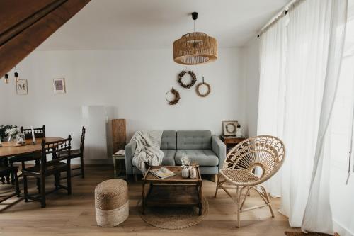a living room with a couch and a table at Les Fleurs de Maria in Le Bourg-Dun