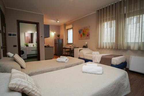a hotel room with three beds and a bathroom at Bnbook Expo Residence Rho in Rho