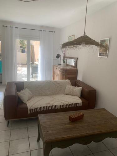 un salon avec un canapé et une table basse dans l'établissement L'olivier de Nonna, à Gruissan