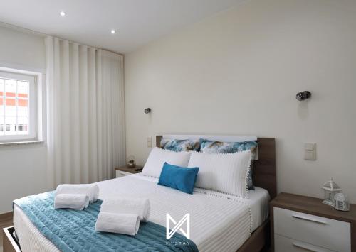 una camera da letto con un grande letto con accenti blu di MyStay - Oliveira Douro House a Peso da Régua