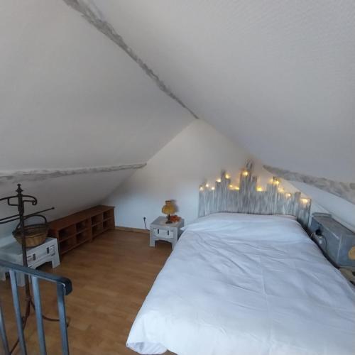 a bedroom with a white bed with lights on it at Le petit nid de Muzy in Muzy